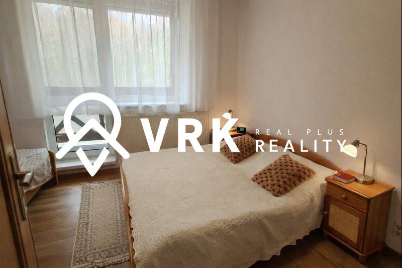 Bedroom in a 3-room apartment with a wooden decor floor and a large window.