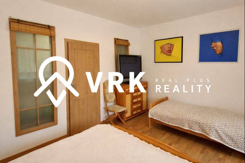 A bedroom in a 3-room apartment with two beds, a television, and a wooden decor floor.