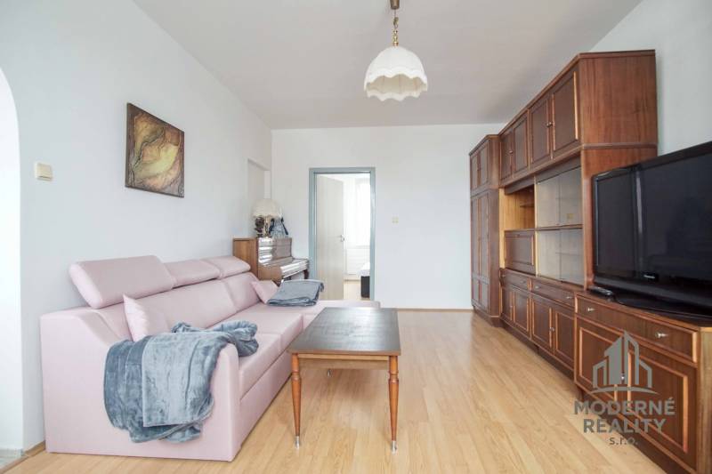 Living room in a 3-room apartment, sofa, wooden decor flooring, piano, furniture.