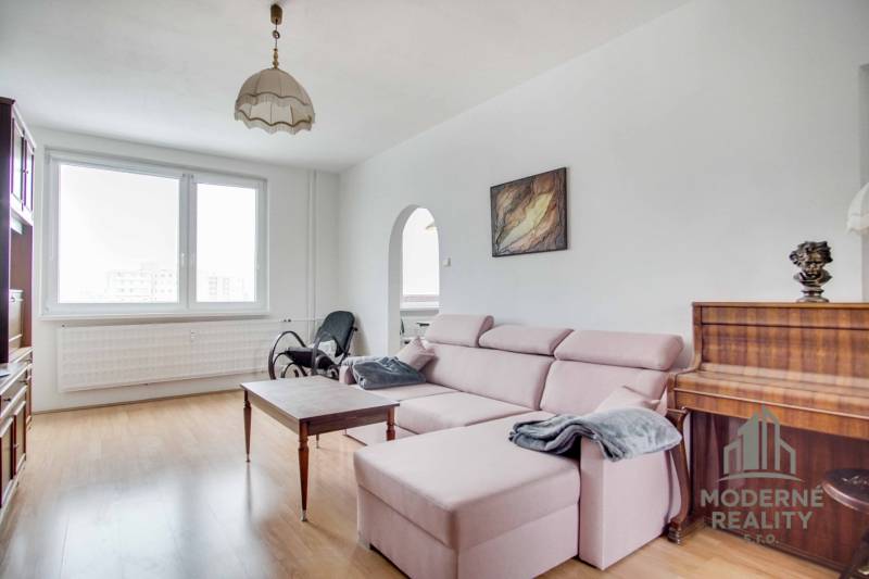 Living room in a 3-room apartment with a wooden decor floor and a comfortable sofa.