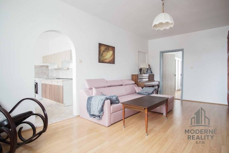 Living room in a three-room apartment with a touch of comfort and a wooden decor floor.