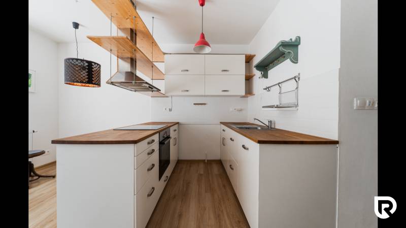 A kitchen corner in a 2-room apartment with wooden decor and pendant lights.