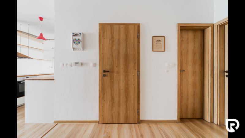 Interior of a 2-room apartment with a wooden decor floor and wooden doors.