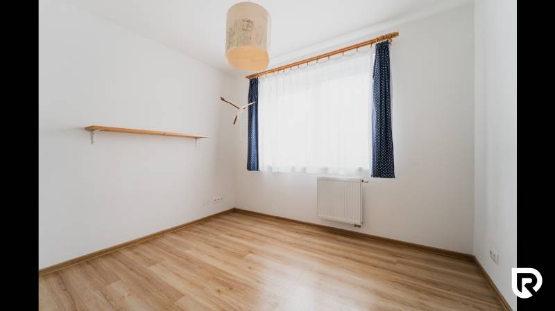 A bright room with a shelf and a wooden decor floor in a two-room apartment.
