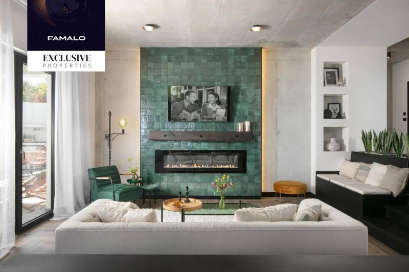 Interior of a villa with a green-tiled fireplace, comfortable seating, and a wooden-patterned floor.