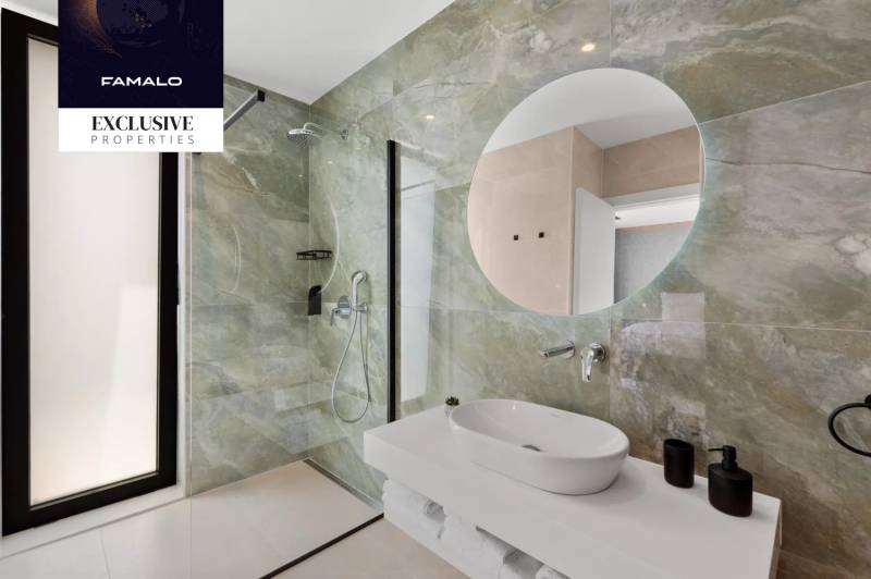 Bathroom with a sink, shower, and mirror in the villa.