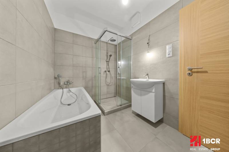 A bathroom in a 3-room apartment with a bathtub, shower, and modern sink.