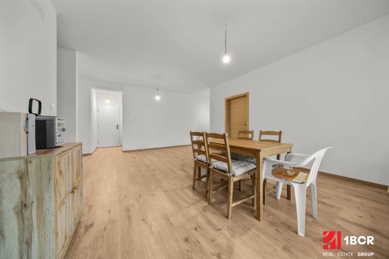 Dining room with a wooden table and chairs, floor with wooden decor, 3-room apartment.