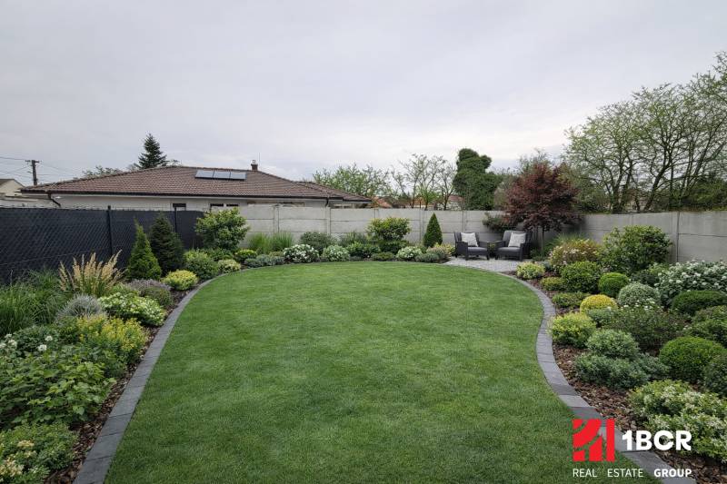Well-maintained garden with a terrace of a family house in Veľký Grob, rich in greenery and planting.