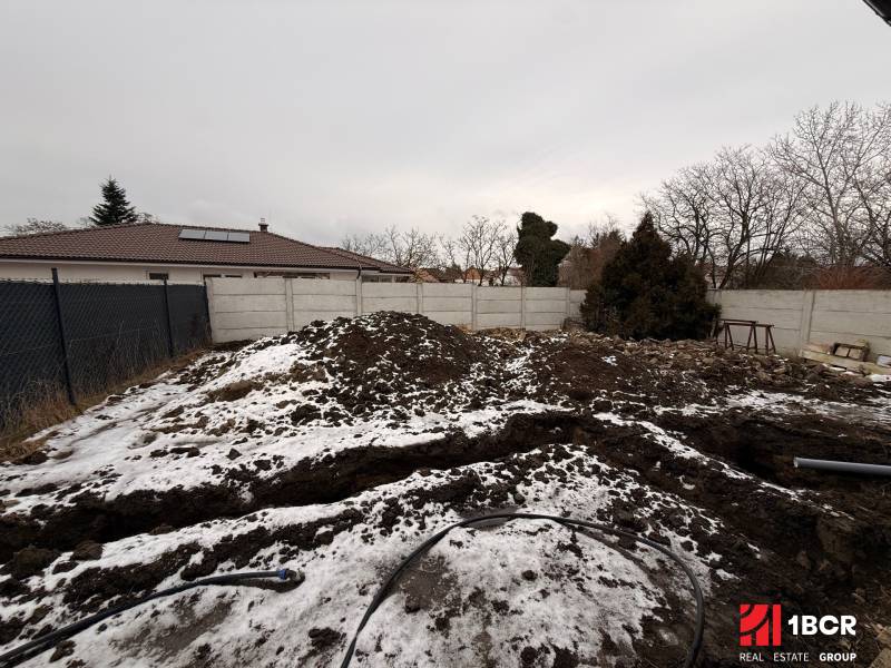 A snow-covered building plot near a family house in Veľký Grob.