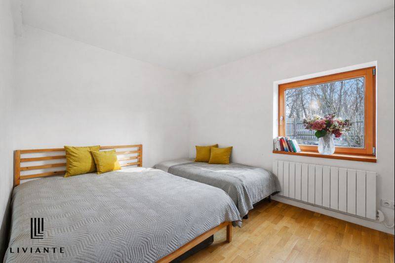 Bedroom in a building with wooden decor, two beds, and window decorations.
