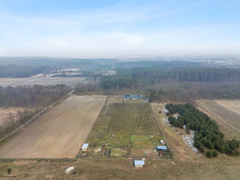 In the rural area of Láb, there is a farm building surrounded by fields and forest.