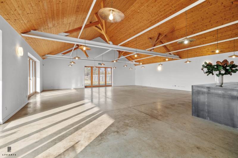 Spacious interior of a building with a wooden ceiling and concrete floor.