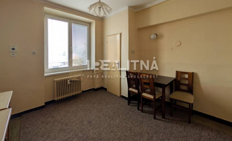 Simple kitchen in a 2-room apartment with a dining table and two chairs.