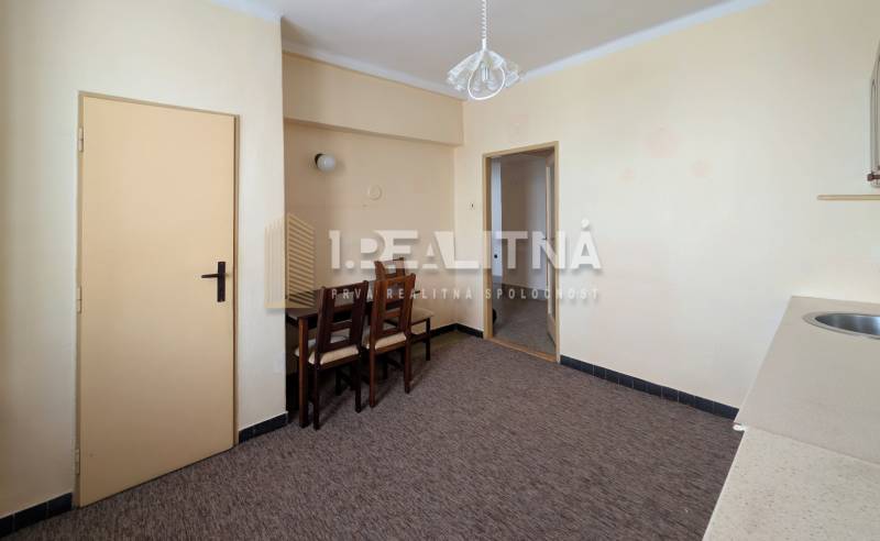 Dining table and chairs in a 2-room apartment with a wooden decor floor.