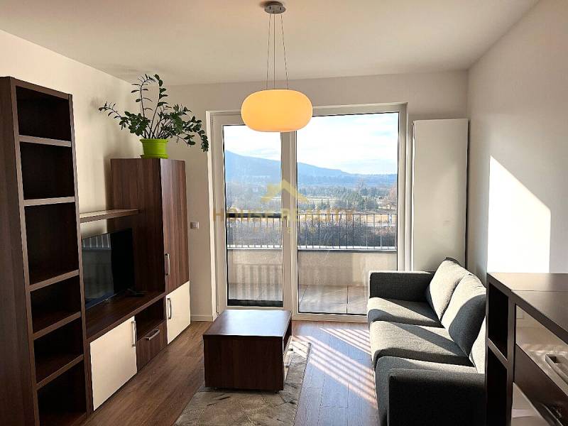 Living room in a two-room apartment with a comfortable sofa and a view from the balcony.