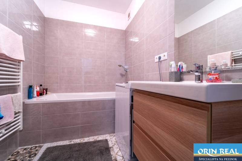 Bathroom with tiles and a bathtub in a 2-room apartment.