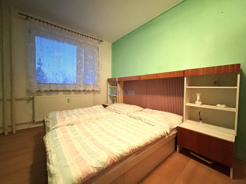 A two-room apartment with light walls, a large window, and a floor with a wooden decor.