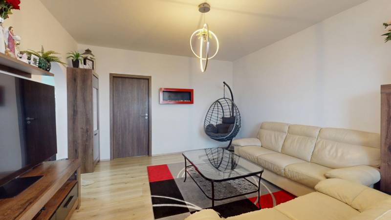 Living room in a 3-room apartment, white sofa, rocking chair, floor with wooden decor.