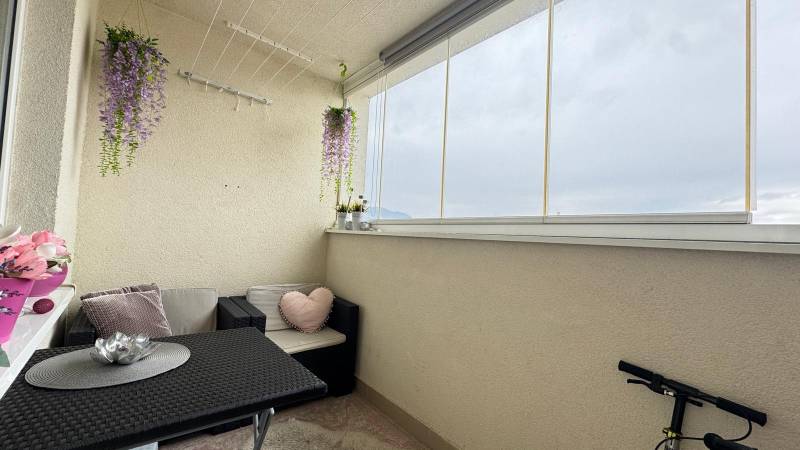 Glazed loggia in a 3-room apartment with comfortable seating and decorations.