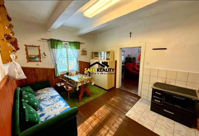 The interior of a cabin with a comfortable sofa, dining table, and wooden decor flooring.