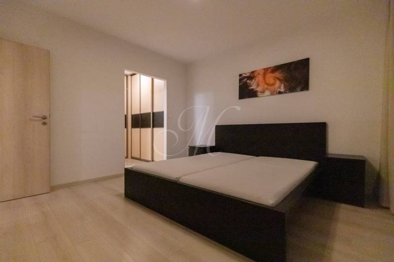 Bedroom in a 2-room apartment with a bed and a wardrobe, floor with wooden decor.