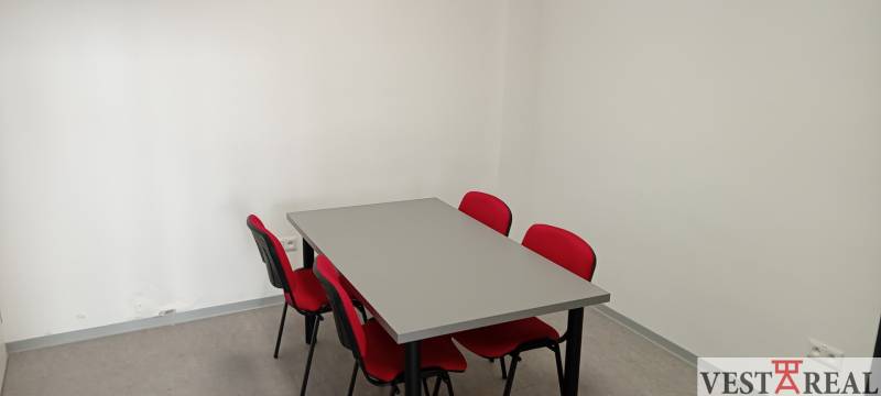 Four red chairs and a gray table in the office.