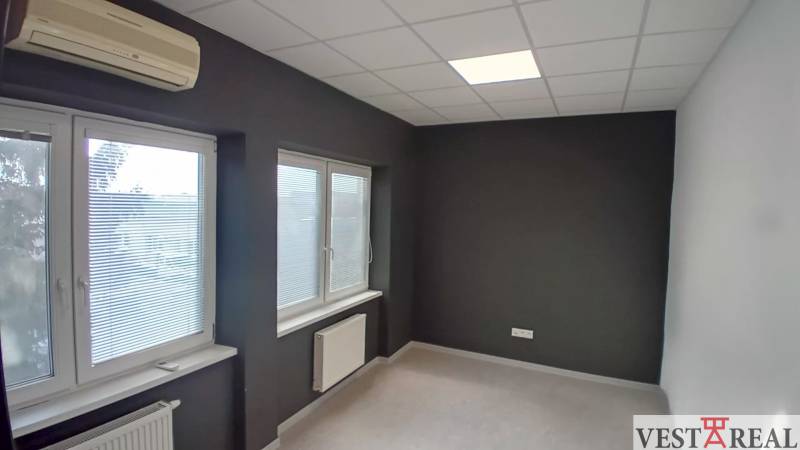 Offices with dark walls, windows with blinds, air conditioning, and radiators on the walls.