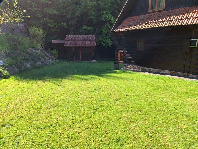 A wooden cottage on Vrátňanská Street in Terchová surrounded by lawn and forest.