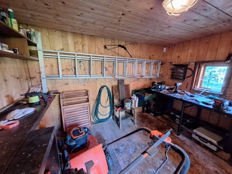 Wooden interior of a workshop with tools and a ladder, floor with wooden decor, Cottage.