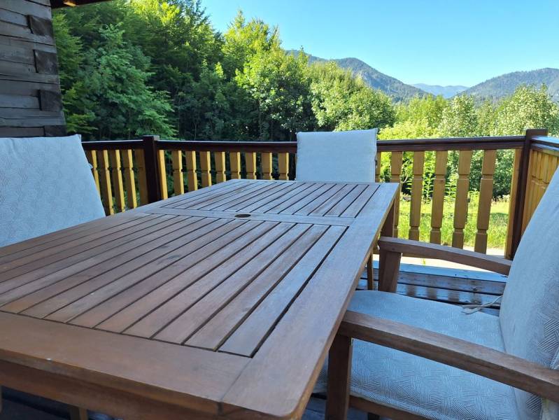 Wooden table and chairs on the terrace of the Cottage with a view of the mountains in Terchová in Vrátňanská.