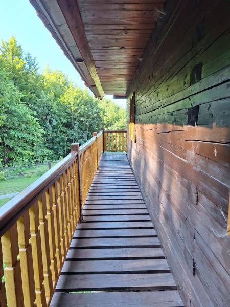 A wooden terrace at a cottage in Terchová on Vrátňanská Street, surrounded by the greenery of the forest.