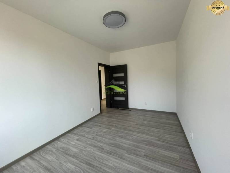 Interior of a family house with white walls, dark doors, and a floor with a wood decor.