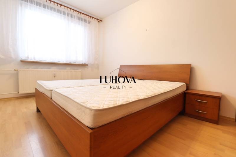 Bedroom in a 3-room apartment with a bed, nightstand, and floor with a wooden decor.