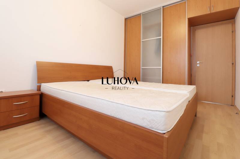 Bedroom in a 3-room apartment with a bed and a built-in wardrobe, floor with wood decor.