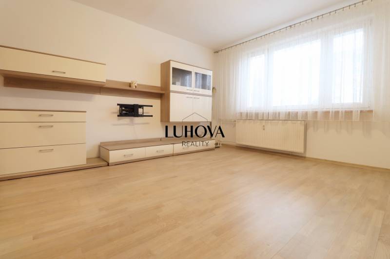 Living room with a large window and wood-patterned flooring, 3-room apartment.