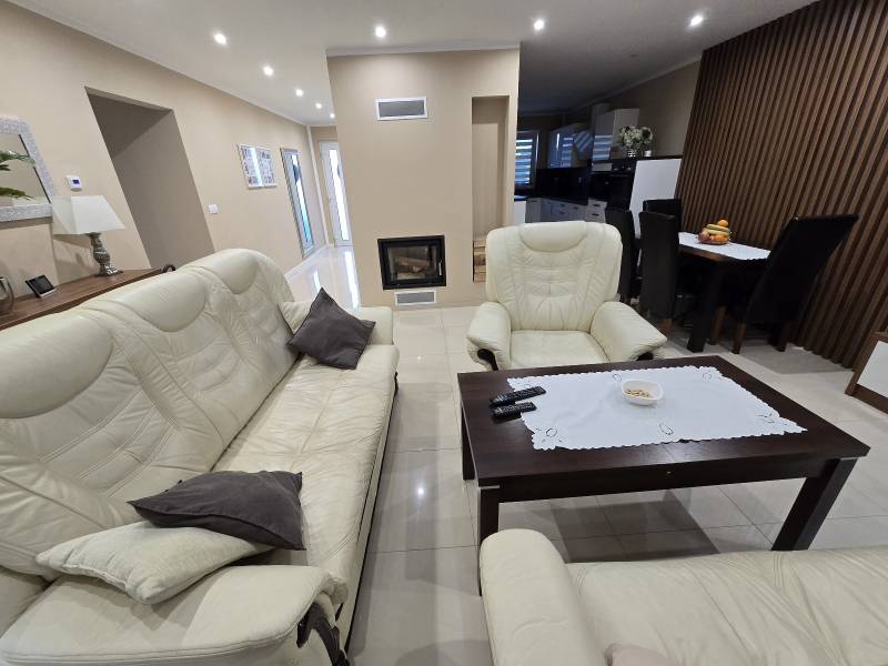 Living room in a family house with a light-colored sofa set and a table on the floor.