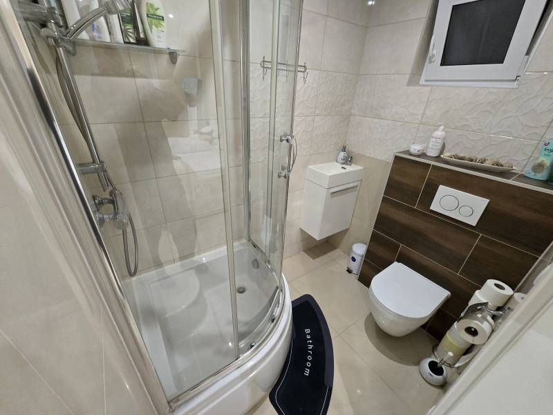 A bathroom in a family house with a bathtub, sink, toilet, and window.