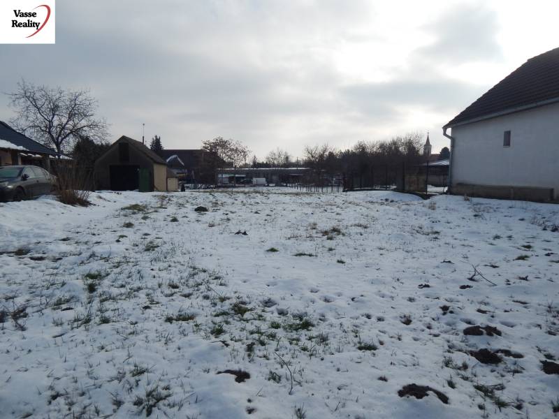 Snow-covered residential lands in Čalovec with buildings and trees.
