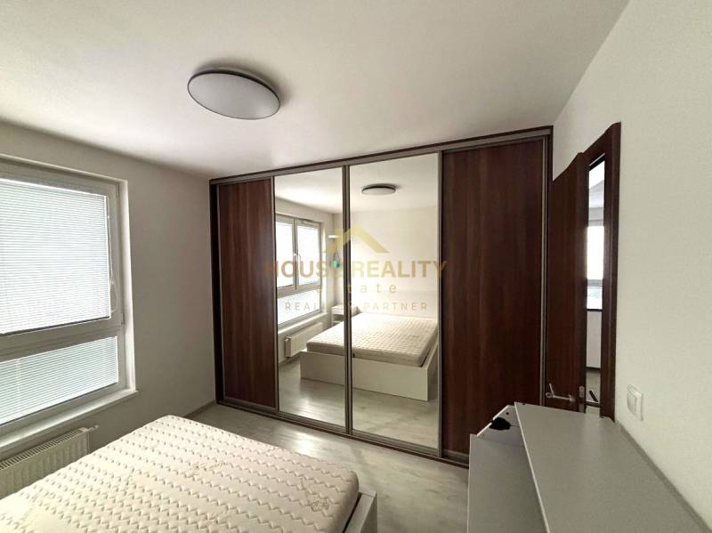 Bedroom in a 2-room apartment with a large wardrobe and a bed.