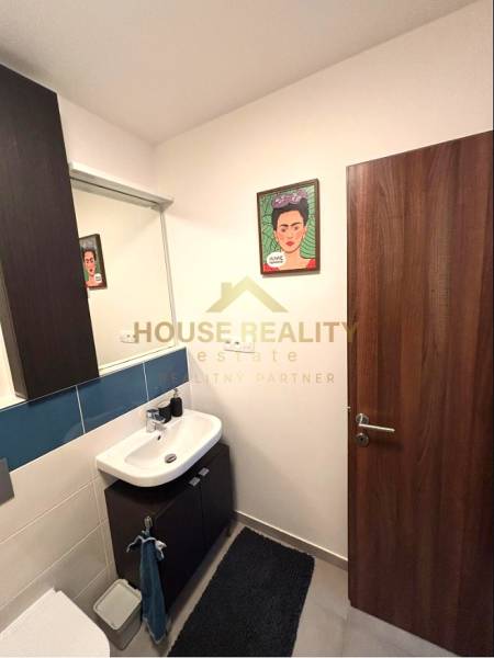 Bathroom with a sink, mirror, painting, and floor in a 2-room apartment.