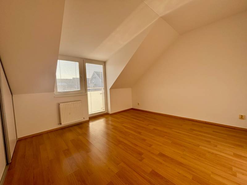 A room in a 2-bedroom apartment with a wooden decor floor and access to a balcony.