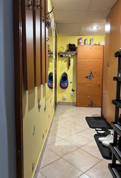 A narrow entrance area in a one-room apartment with coat racks and shoe cabinets.