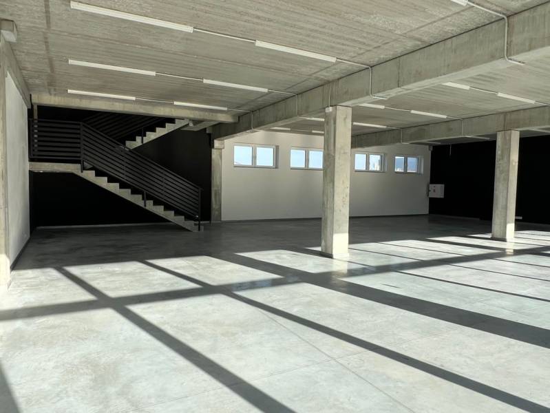 Empty commercial spaces with a concrete ceiling and staircase, floor with concrete decor.