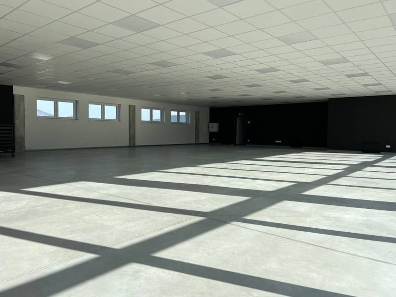 Spacious commercial spaces with a white ceiling and light tiles on the floor.