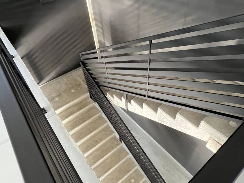A staircase with a metal railing in commercial premises.