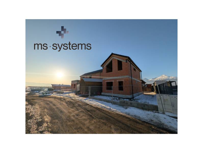 A family house in Mlynica under construction under a blue sky, with a snowy surroundings.