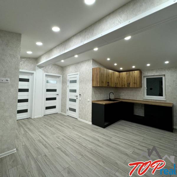 Interior of a family house with a wooden decor floor and a stylish kitchen unit.