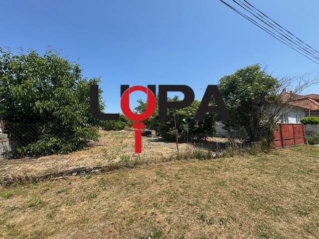 Land for sale in Mužla for residential purposes, surrounded by greenery and a fence.