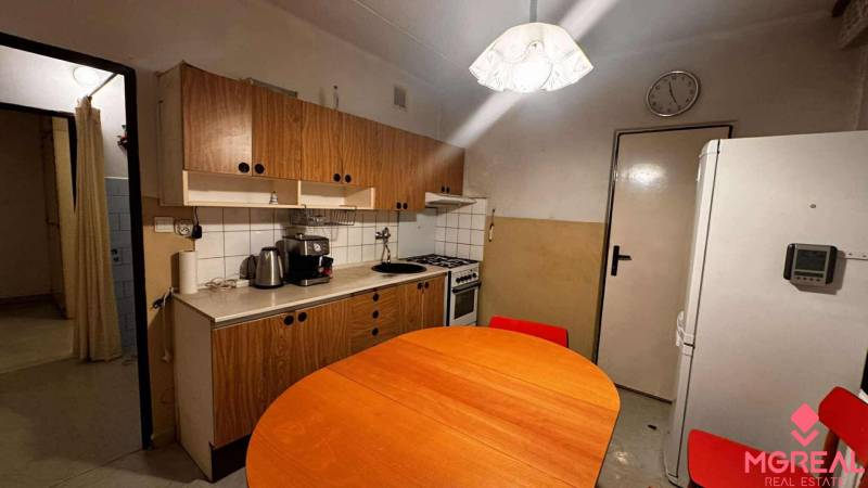 A kitchen in a 2-room apartment with an electric oven and a drawer unit with a wooden decor.